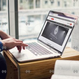 موکاپ لپ تاپ روی میز چوبی در حال کار کردن