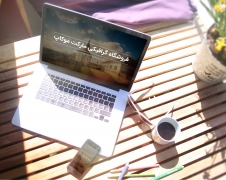 موکاپ مک بوک و آیفون بر روی میز چوبی و کنار لیوان قهوه از نمای بالا
